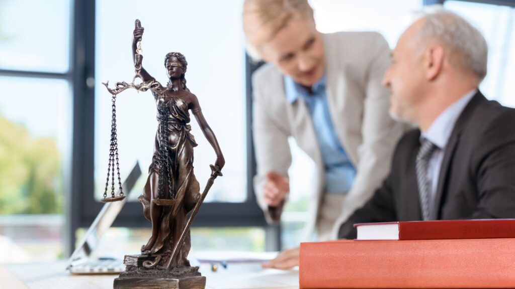 Two Men in a Office with Statue in the Front